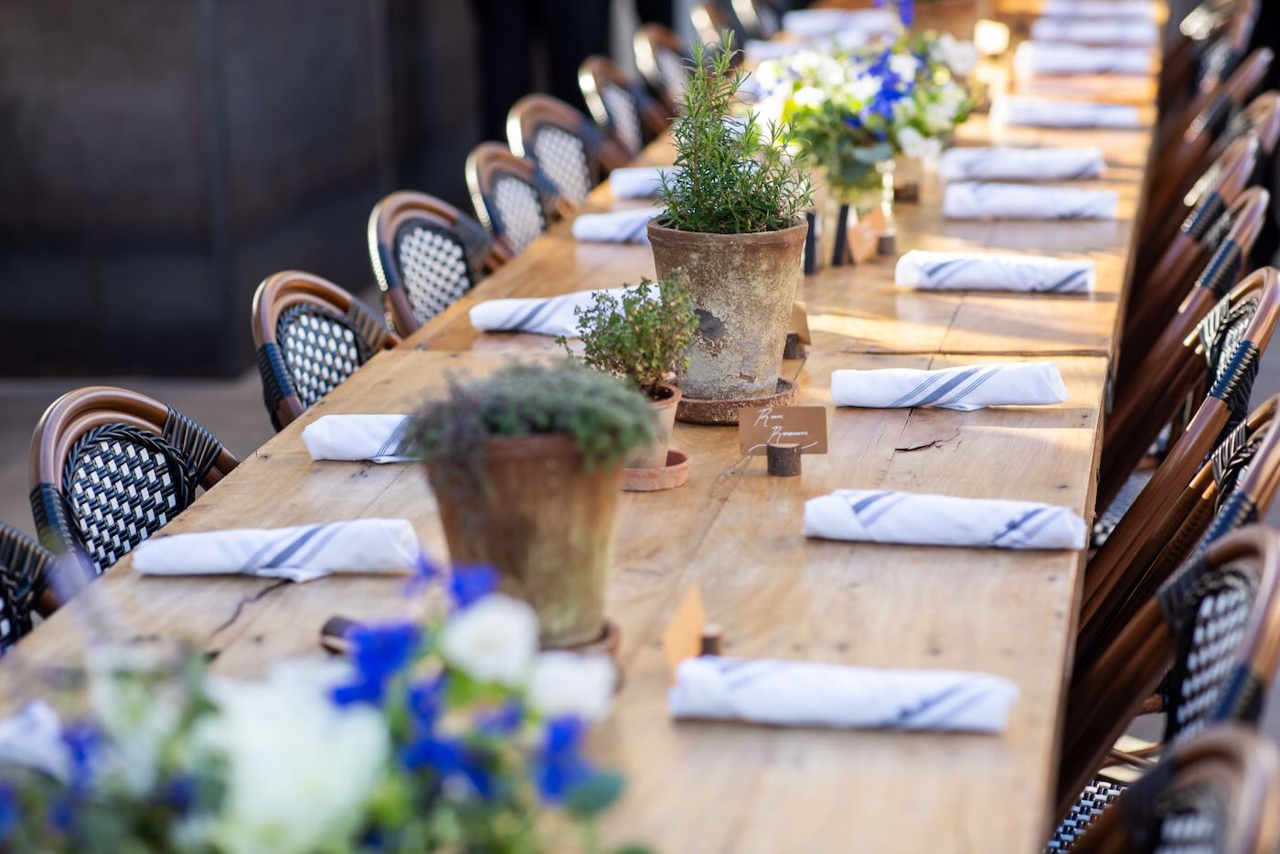 Long farm table with herbs, linen napkins and blue florals